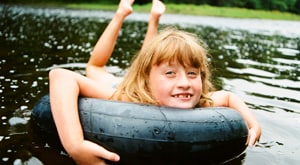 Young girl floating on tube in lake