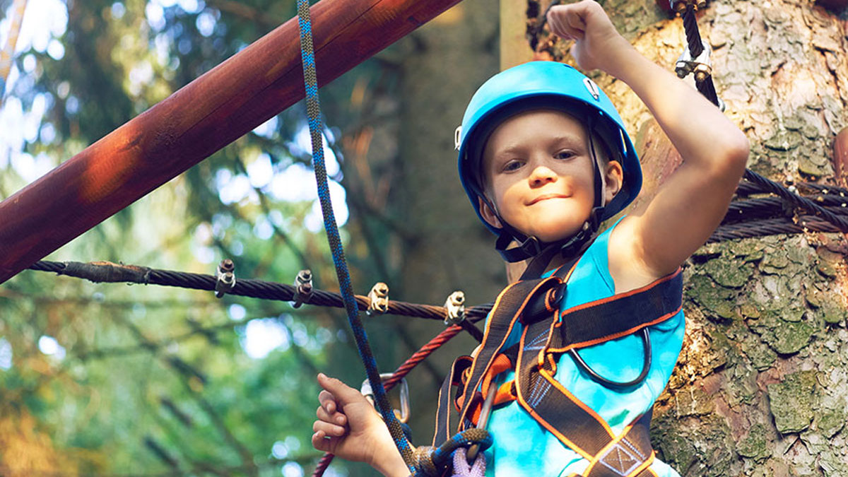 Child in blue helmet completing an obstacle course activity.