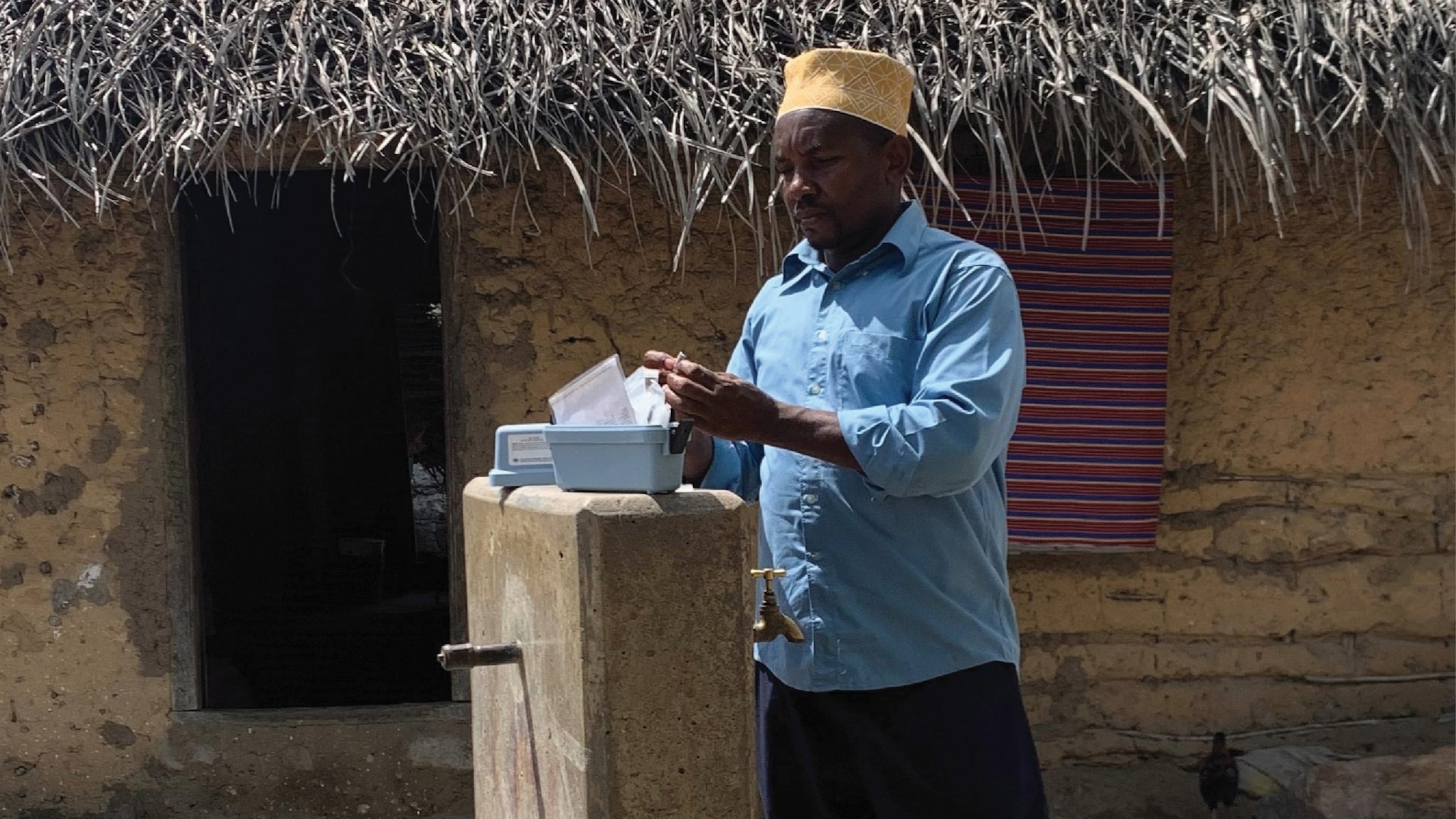 ZAWA technician conducting a monitoring visit at a community tap stand