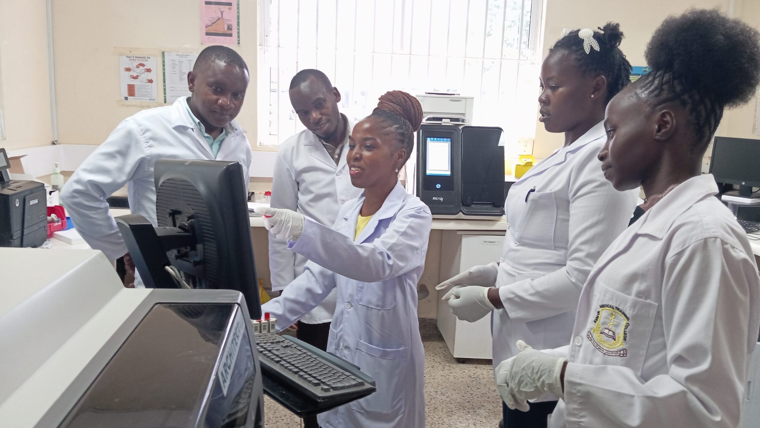Group of lab workers looking at results on a computer screen