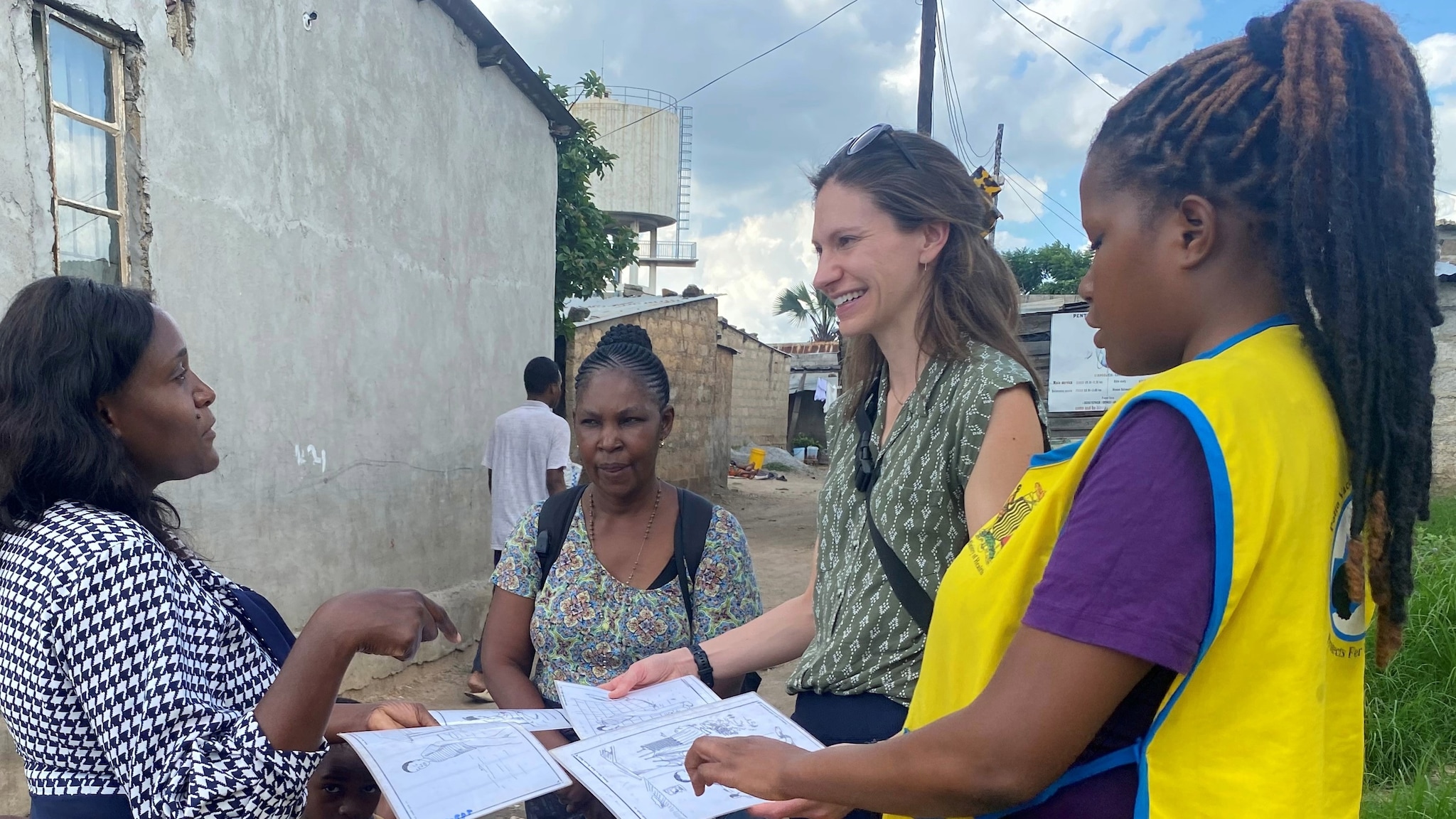 Woman in village smiling while looking at a drawing.