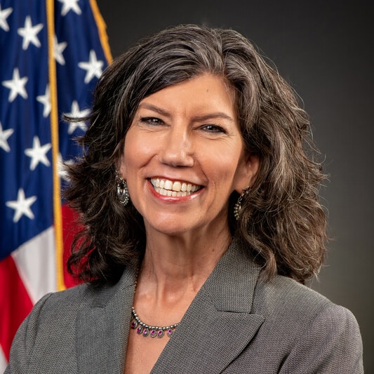 Dr. Laserson leads CDC’s global work to protect and improve health through science, policy, partnership, and evidence-based public health action. Woman with dark gray hair against a gray background with the U.S. flag.