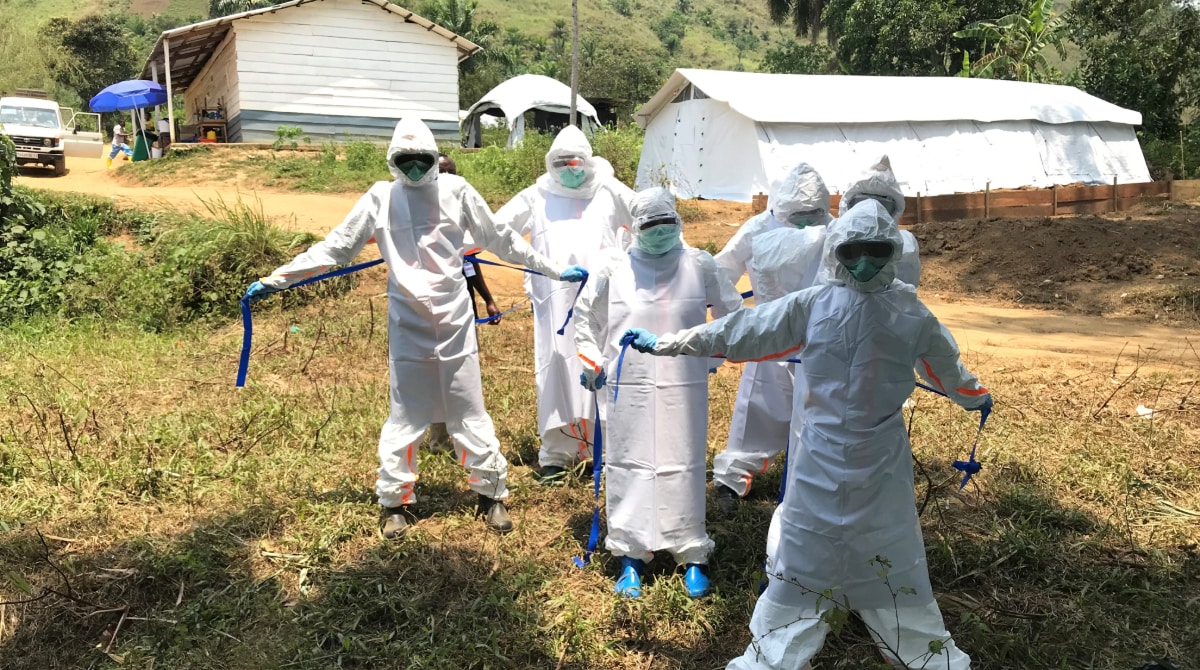 Five public health workers dressed in personal protective equipment during the Ebola response in Congo.