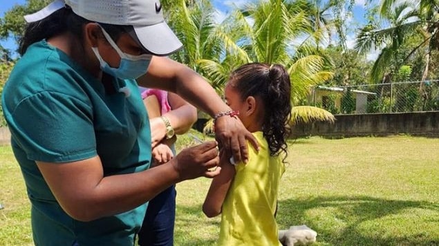 A health worker administers the COVID-19 vaccine to a young girl in Honduras