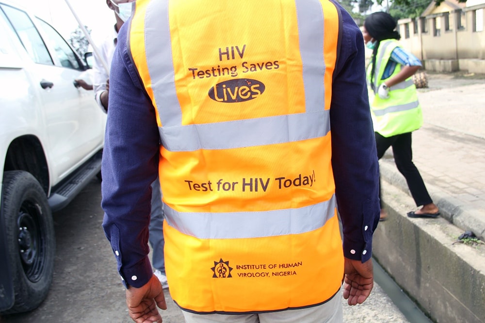 Back of person wearing a vest promoting HIV testing