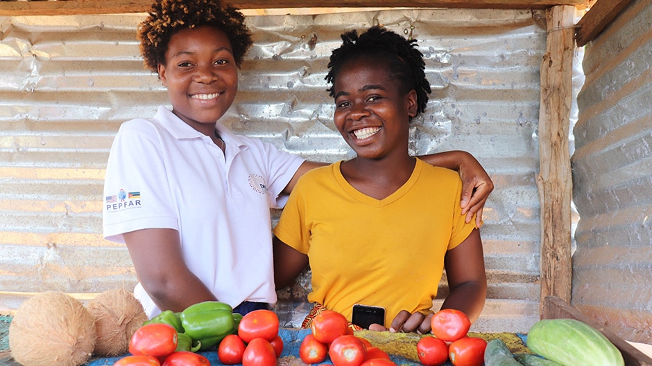 two young women standing at a fruit stall in Mozambique.