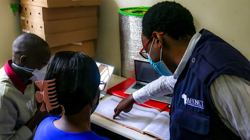 A group of 3 people review a document.