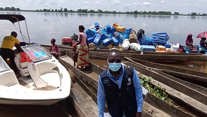 Health worker delivering vaccines by boat