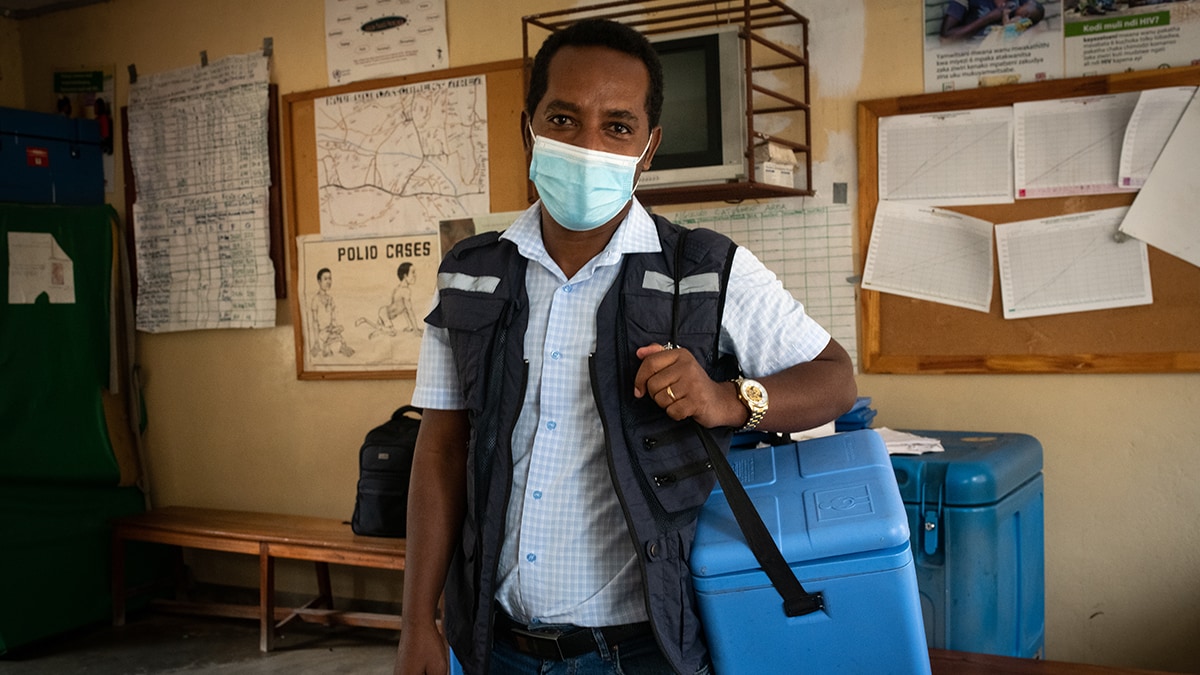 Health worker with a cooler delivering vaccines