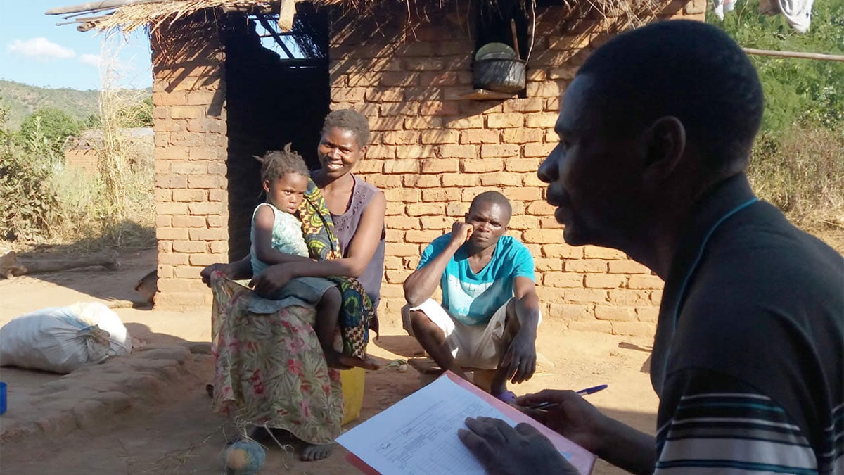 Local public health staff member conducts a vaccination interview with a family in the Rumphi District of Malawi.