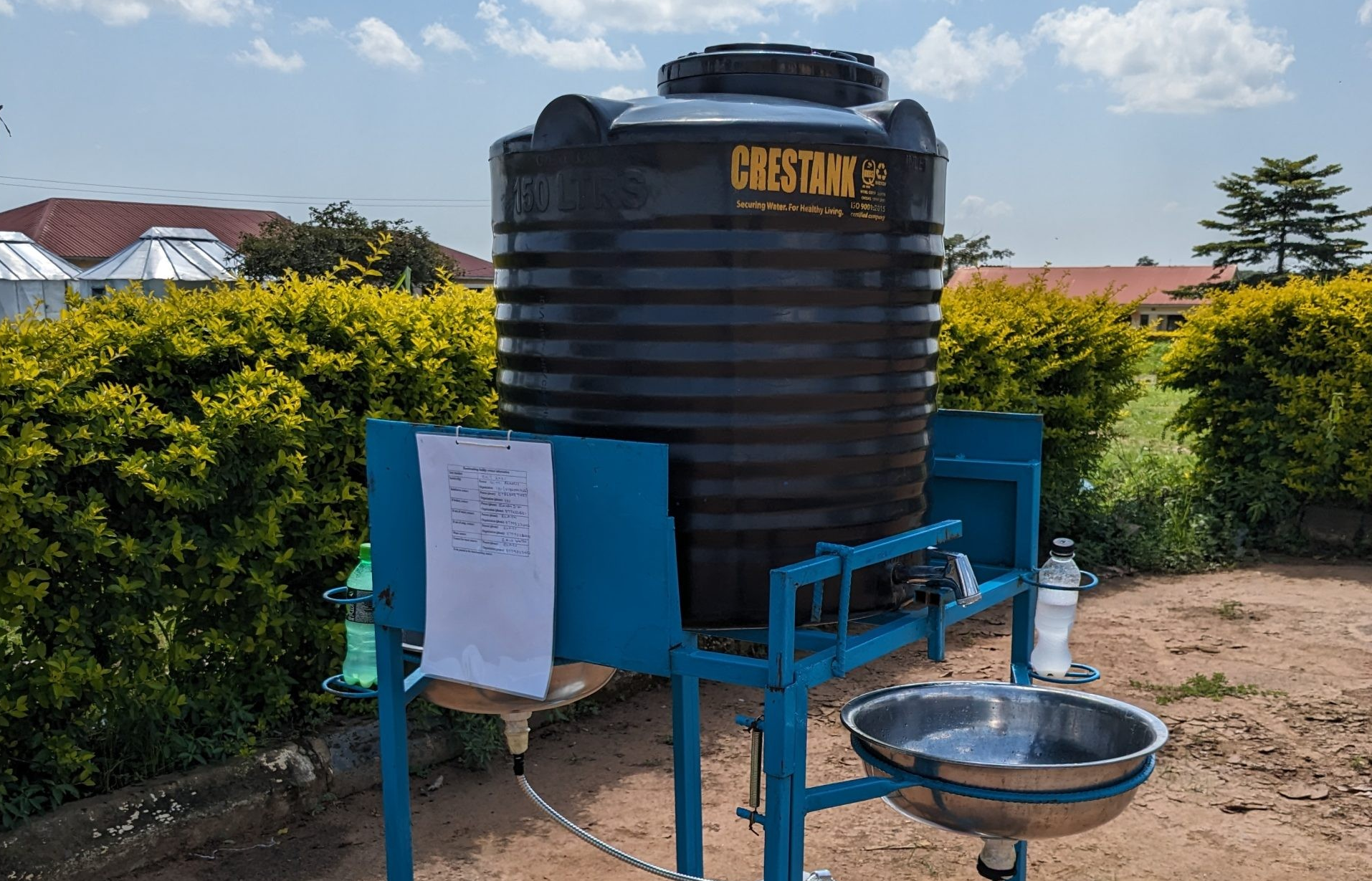 Closeup of an outdoor portable handwashing station, consisting of a large tank and a sink.