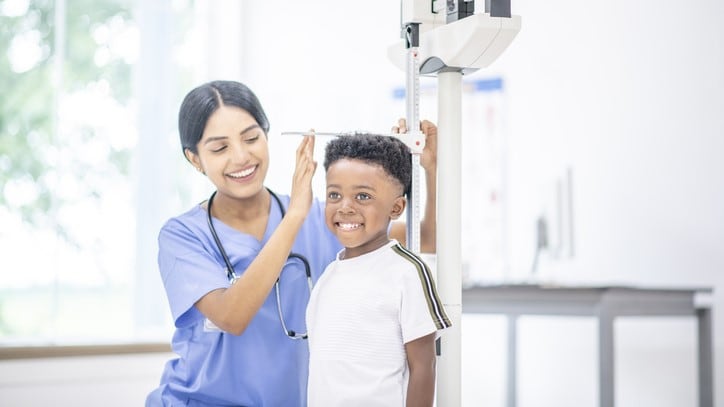 Boy getting his height measured by a nurse.