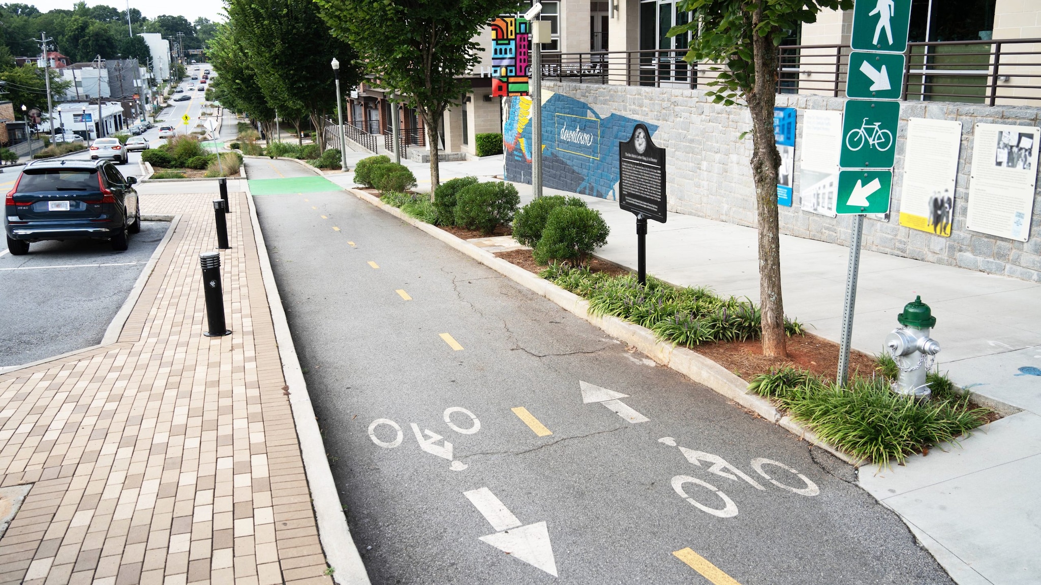 A city street, bike lane, and wide sidewalk.