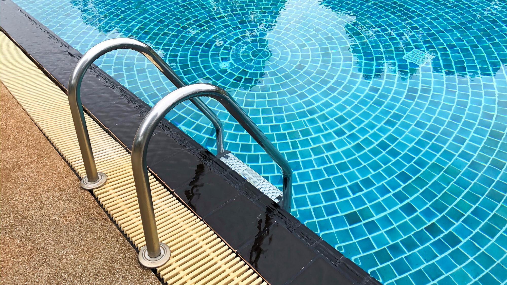 Close up of a ladder going into the deep end of a pool.