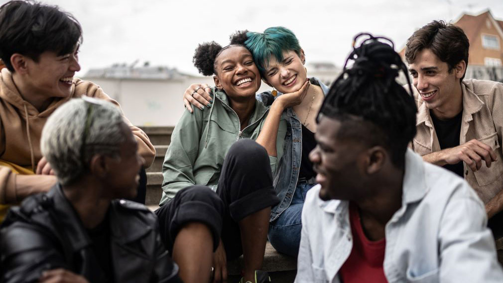 A group of LGBTQ+ youth talking and laughing.