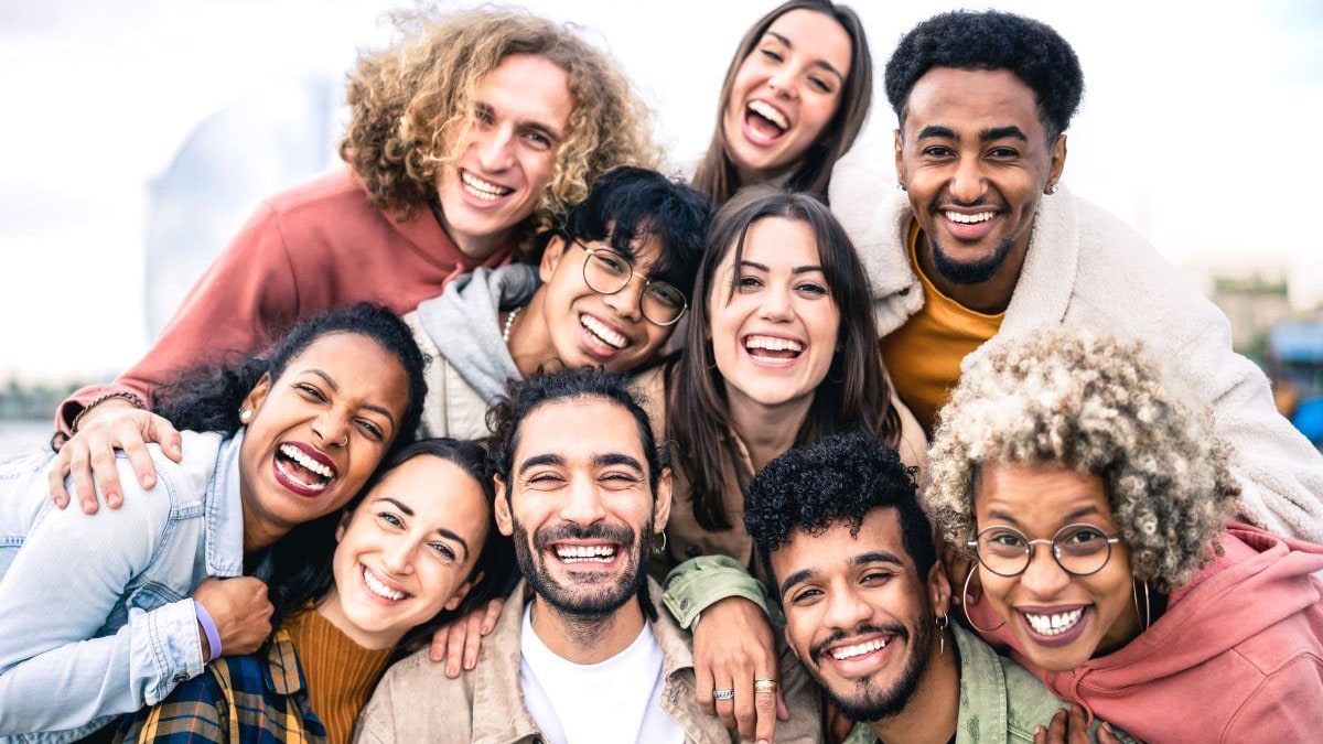 A group of adolescents smiling for selfie.