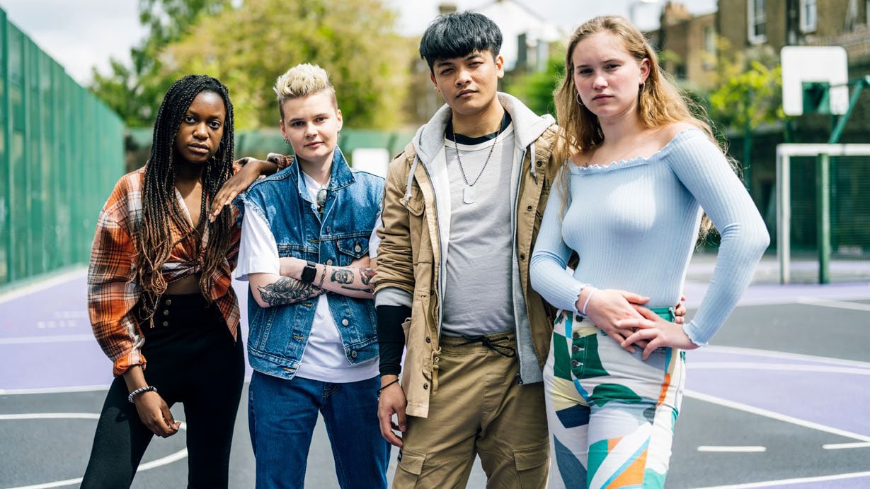 A group of high school students, standing in front of school.