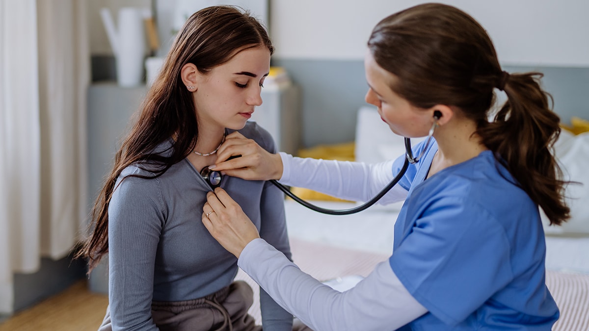 A school nurse checking a female student.