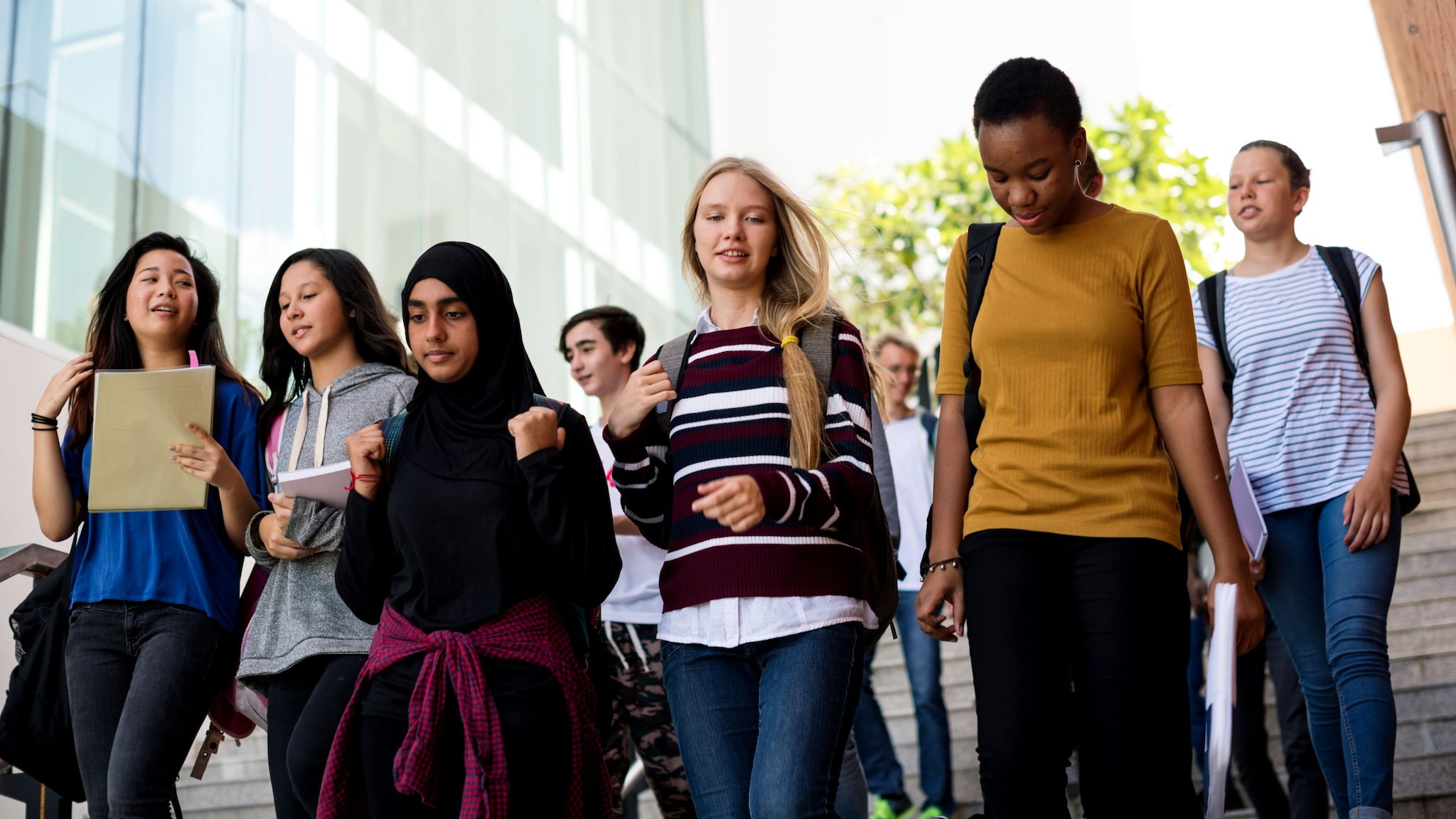 Diverse group of high school students walking to school.