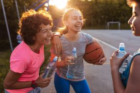 Photo of female coach with her basketball team after training