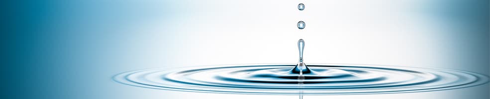 A drop or water falling into a larger body of water causing ripples.