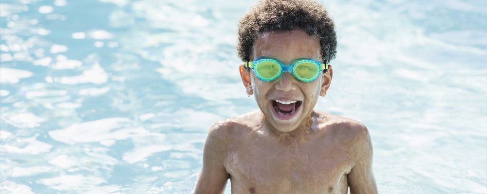 Imagen de un niño con gafas en la piscina