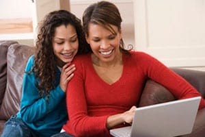 A mother and daughter looking information together over laptop