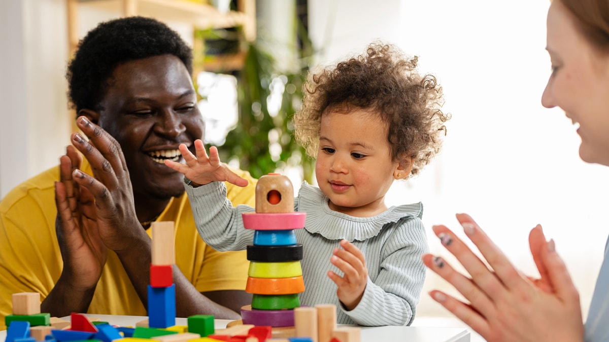 child playing with blocks with parents