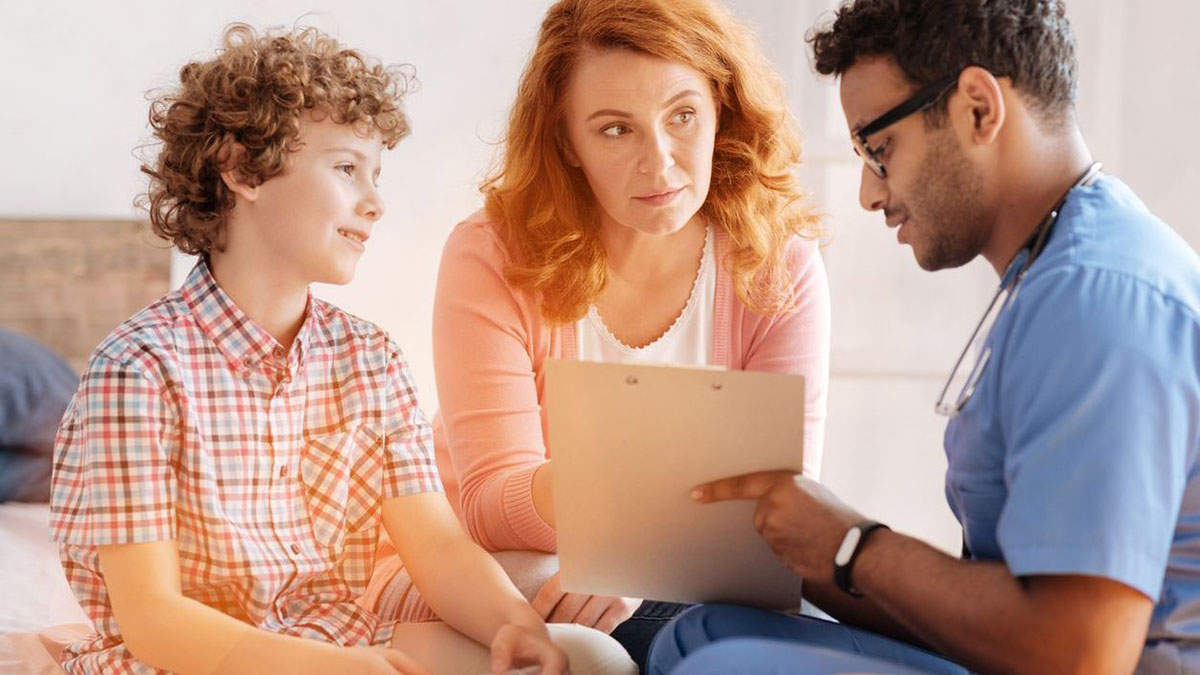 Doctor reviewing chart with a mother and son Doctor reviewing chart with a mother and son