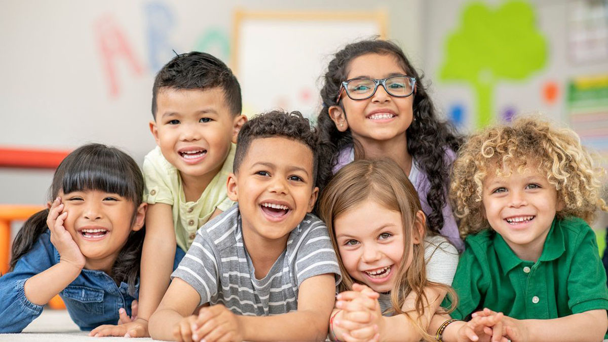 Group of kids posing and smiling in classroom Group of kids posing and smiling in classroom