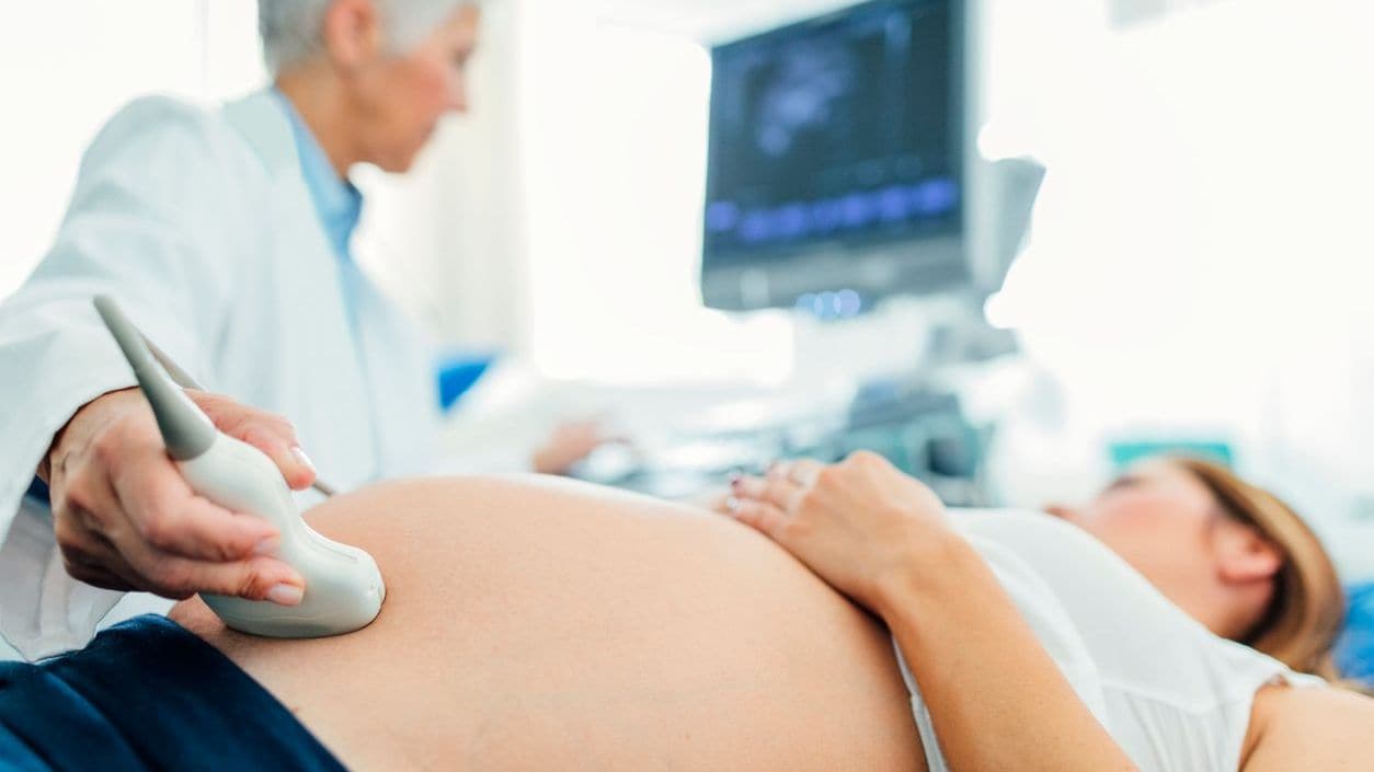 A pregnant woman is getting an ultrasound.