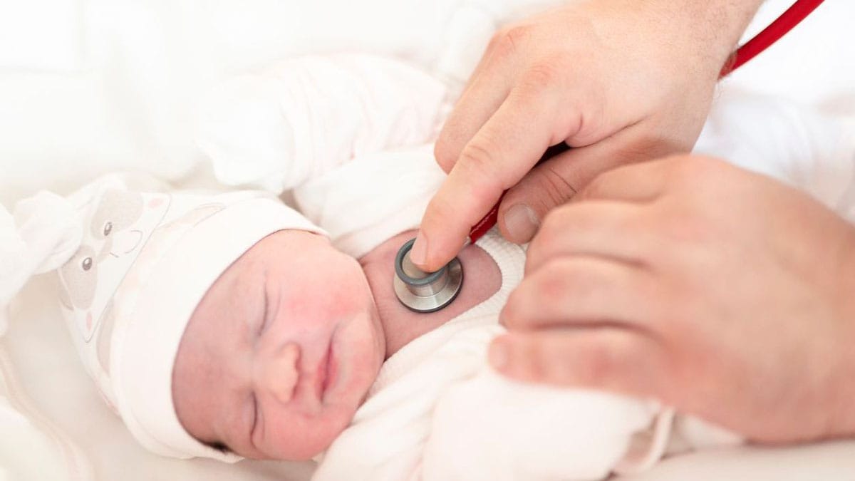 A healthcare professional listening to a baby's heart with stethoscope