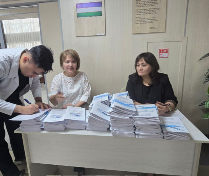 Group of people at a table filled with viral hepatitis training materials.