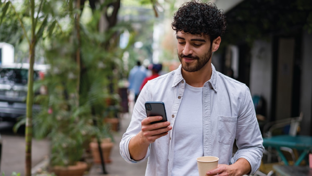 Image of man holding and looking at a smartphone.