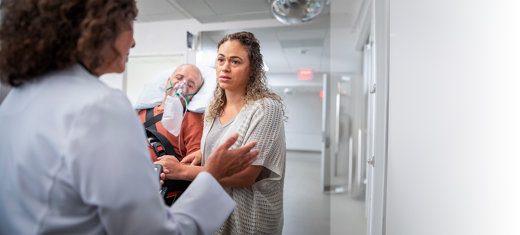 A family member helps a patient in serious condition get care from a doctor
