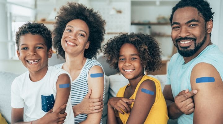 Smiling family with adhesive bandages on their arms
