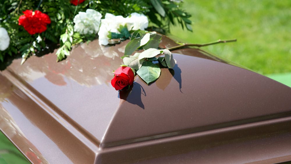 Coffin with flowers on it.