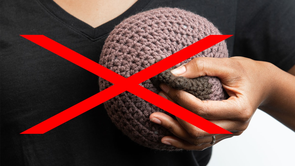 Woman squeezing nipple on crochet breast.