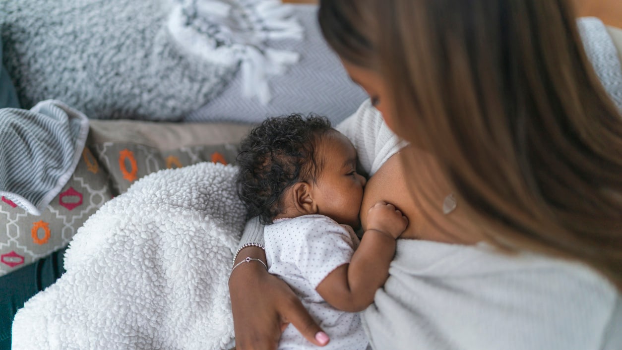 A newborn baby breastfeeds