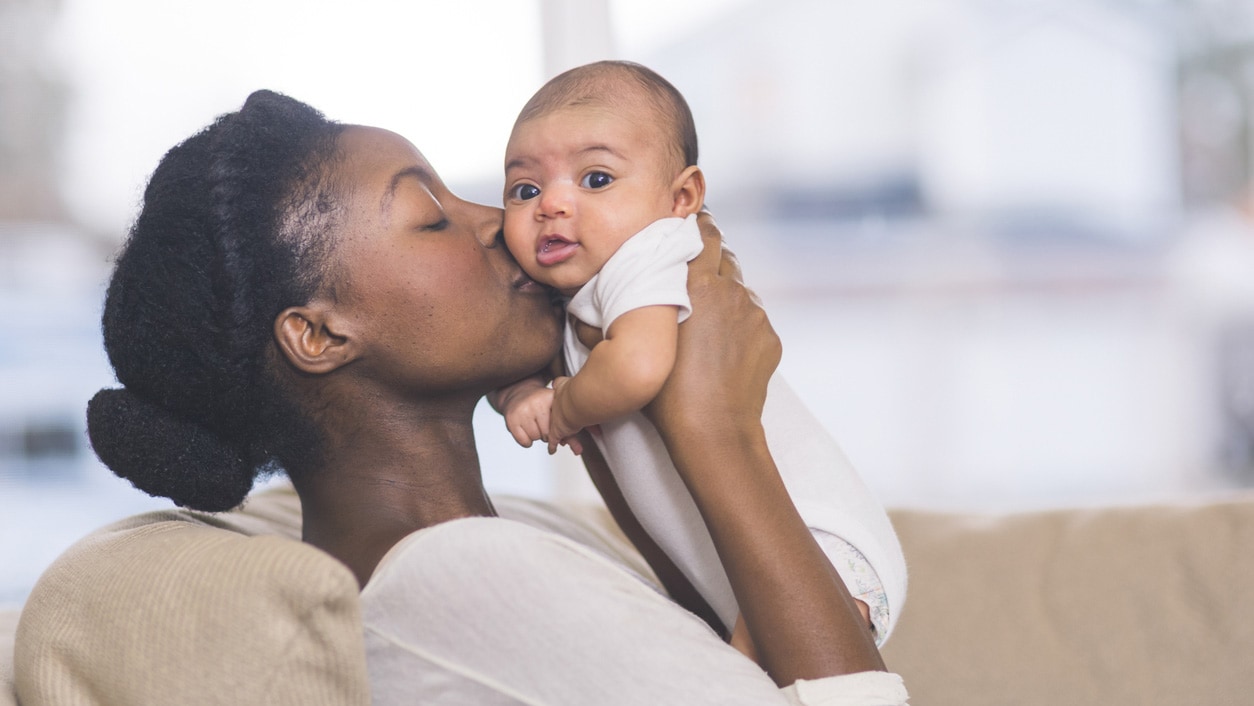 A mother kissing her child.