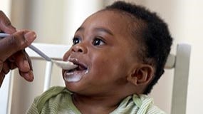 Young child being spoon fed.