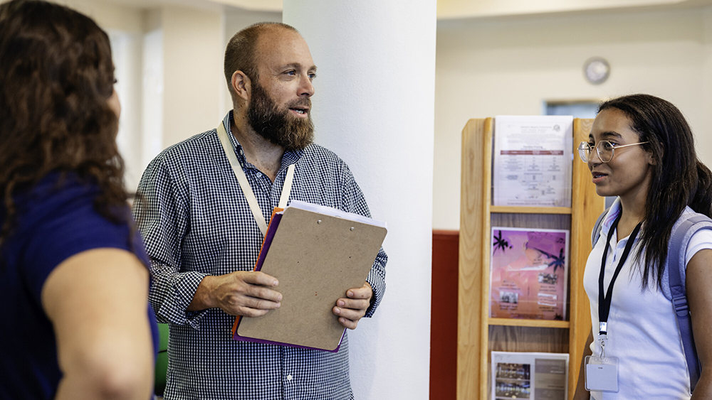 Male faculty member speaks with students