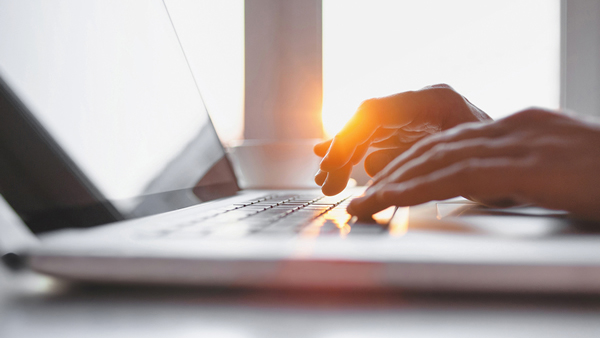 Closeup shot of person's fingers typing on laptop.