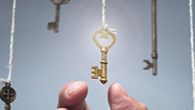 Hand grabbing a key from several hanging keys