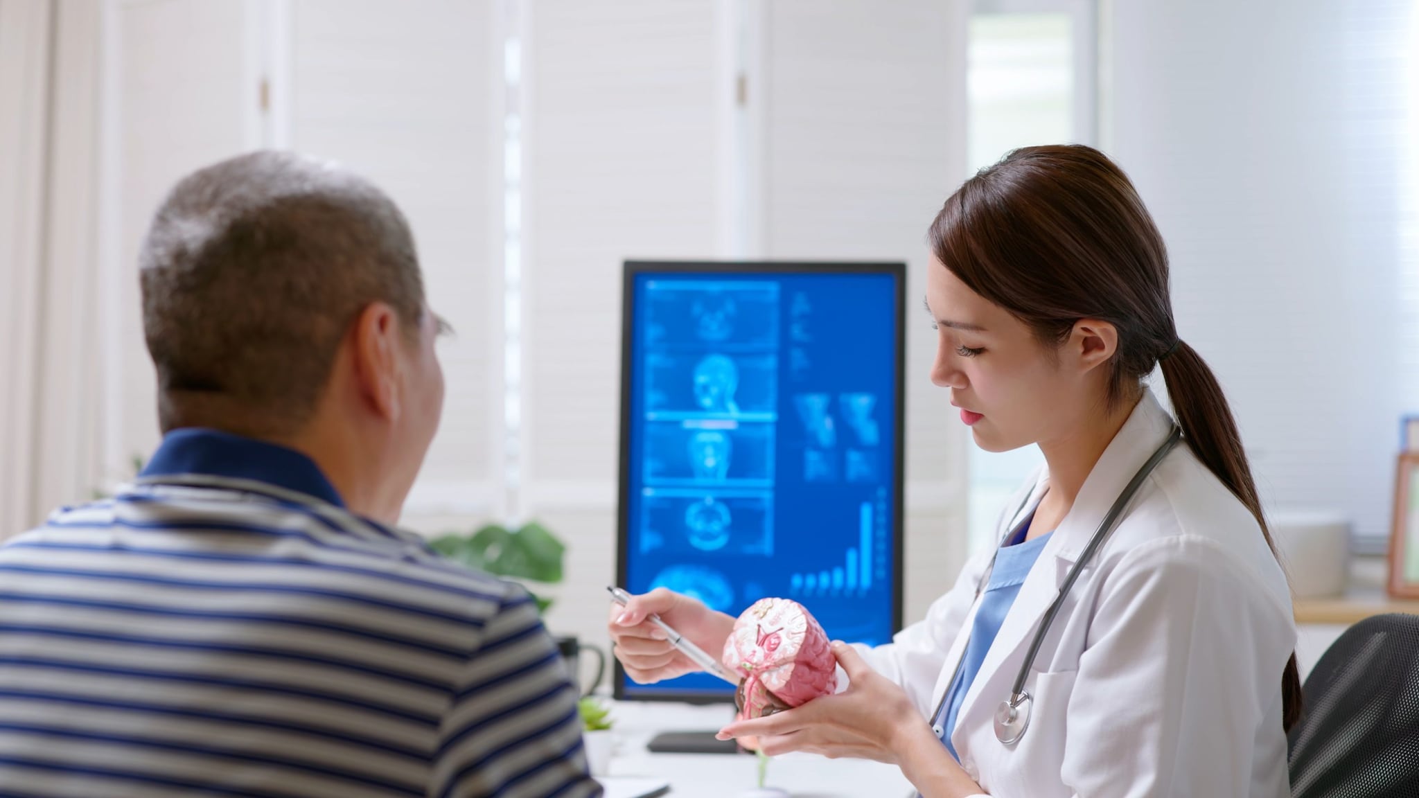 Doctor pointing at a brain model with a patient