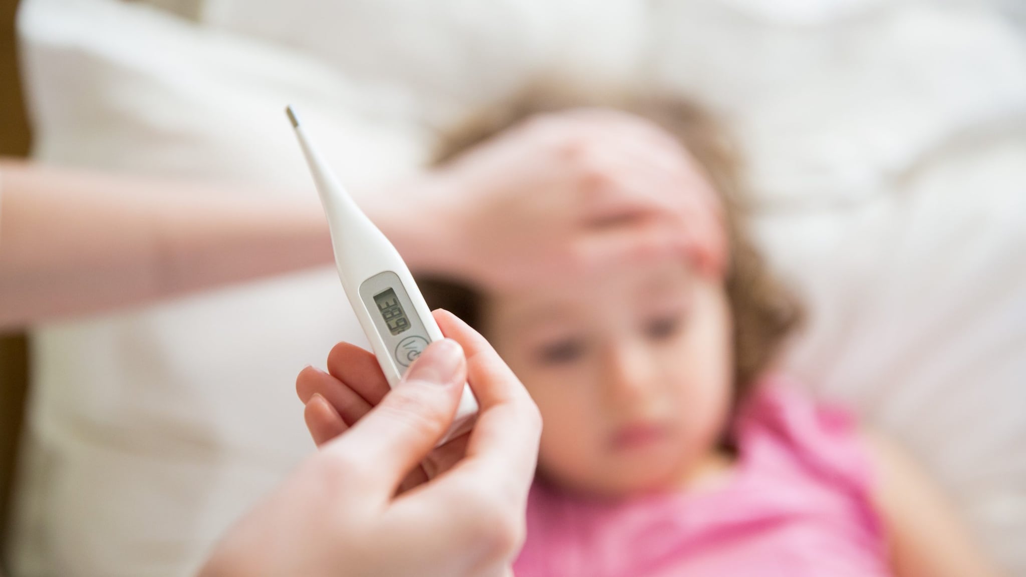 Parent checking child's tempature with a thermometer
