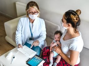 Female doctor consults with mother and child.