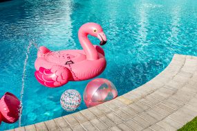 A flamingo pool float in a pool with floatable balls
