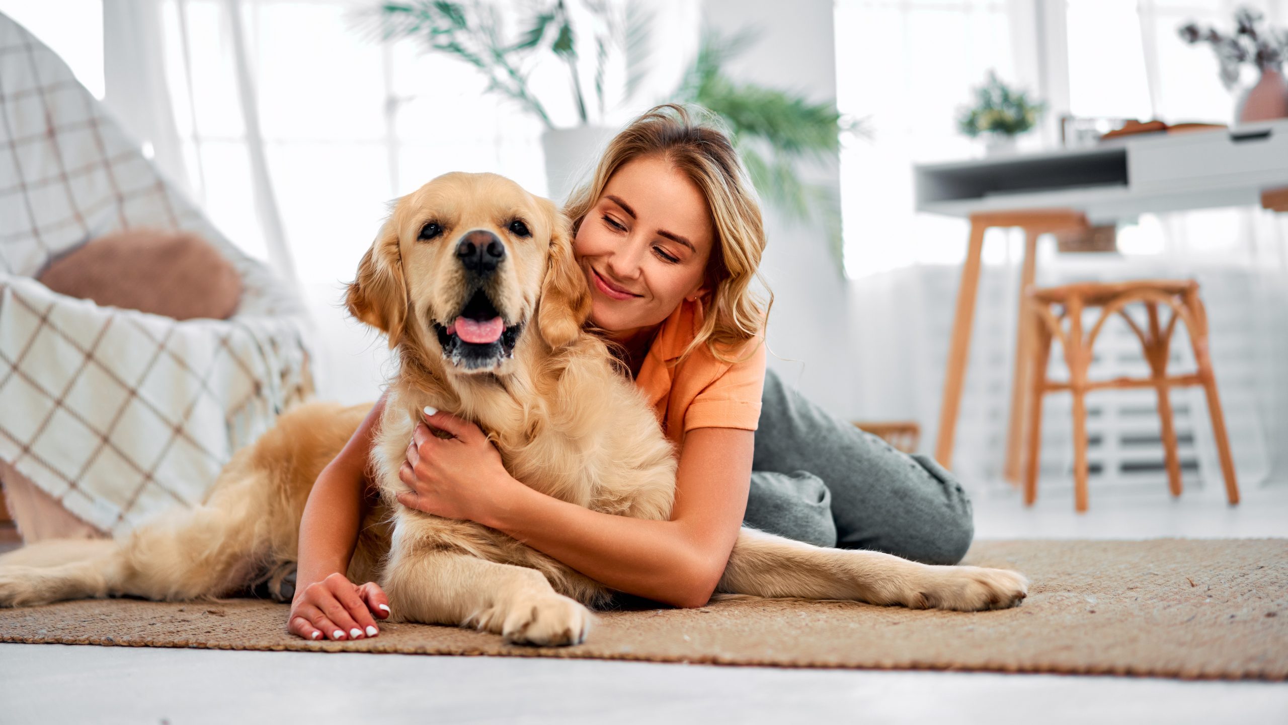 Una mujer abrazando a su perro en el piso