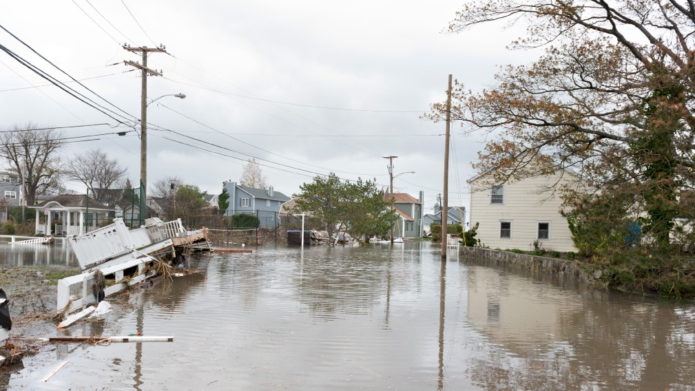 a flooded street and damaged homes
